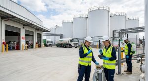 Large industrial fuel storage facility with workers conducting eco-friendly pest inspection